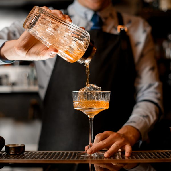 Barman,Gently,Pours,Finished,Cocktail,From,Glass,Shaker,Into,Glass.